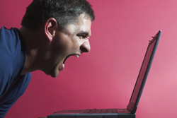 Image of man screaming at a laptop